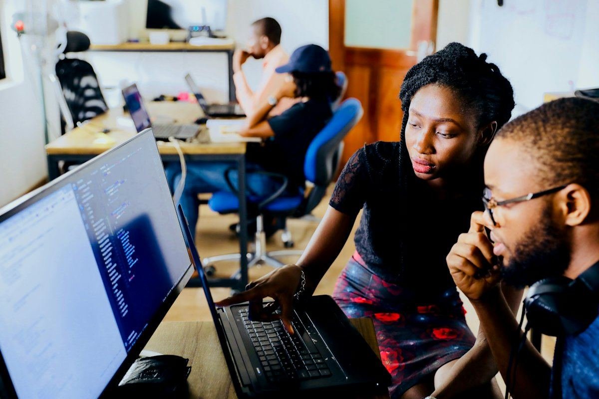 Two colleagues working together at a laptop in an office