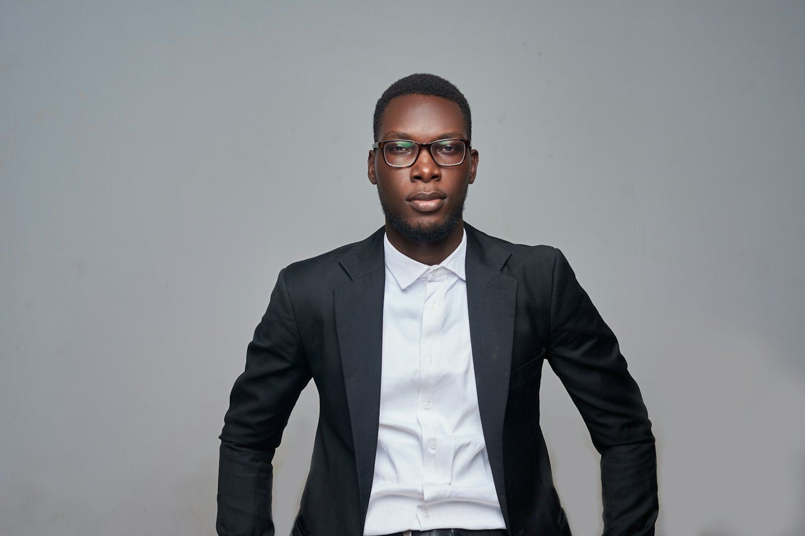 A professional in a dark blazer, white shirt and glasses