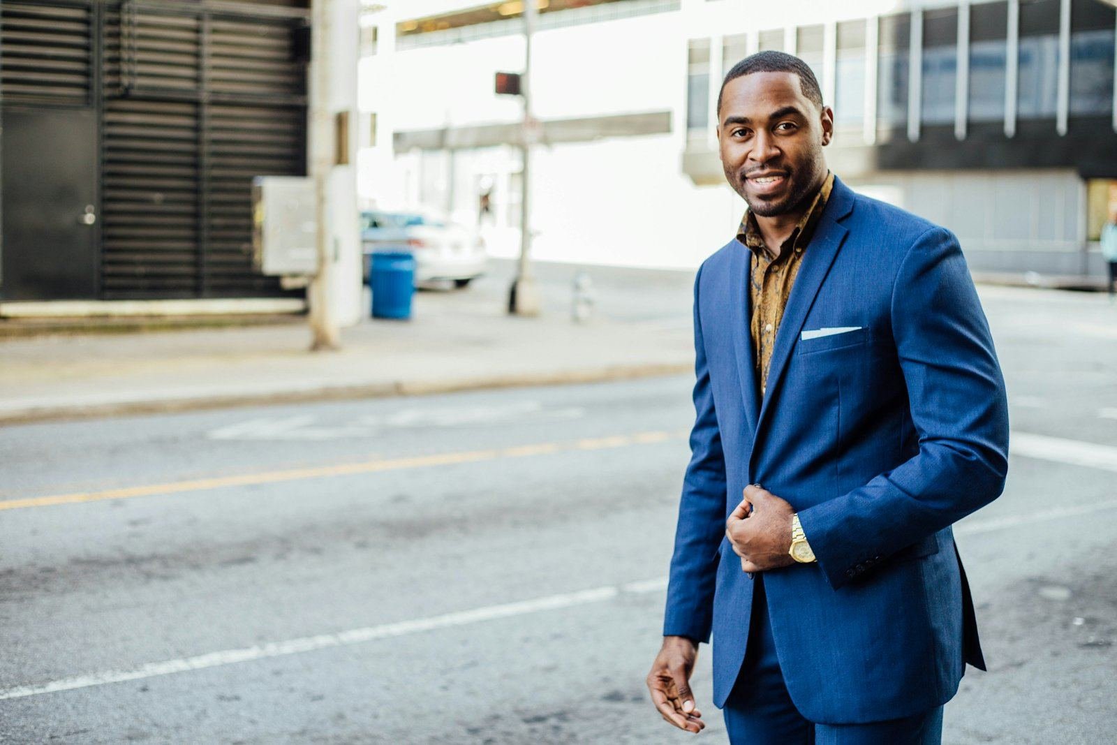 A businessman in a blue suit on a city street
