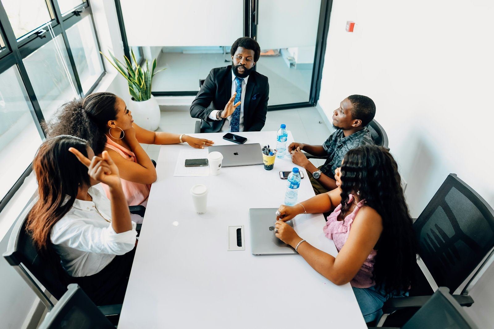 A team in discussion around a conference table in a bright office