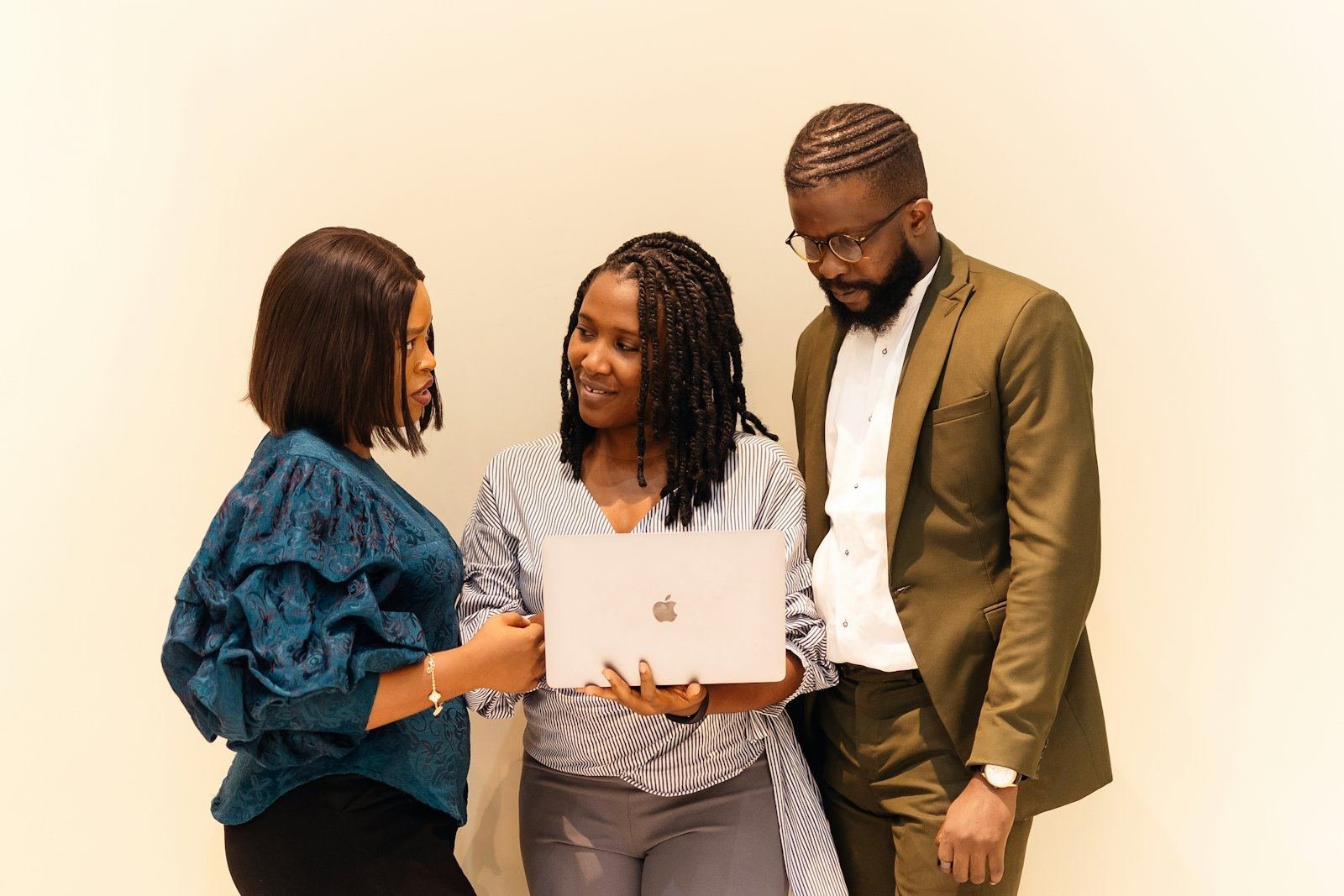 Three professionals looking together at a laptop
